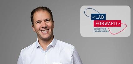 A smiling man in a white shirt stands against a gray background, next to a logo that reads "LAB FORWARD – <lab forward="">CONNECTING LABORATORIES.</lab>
