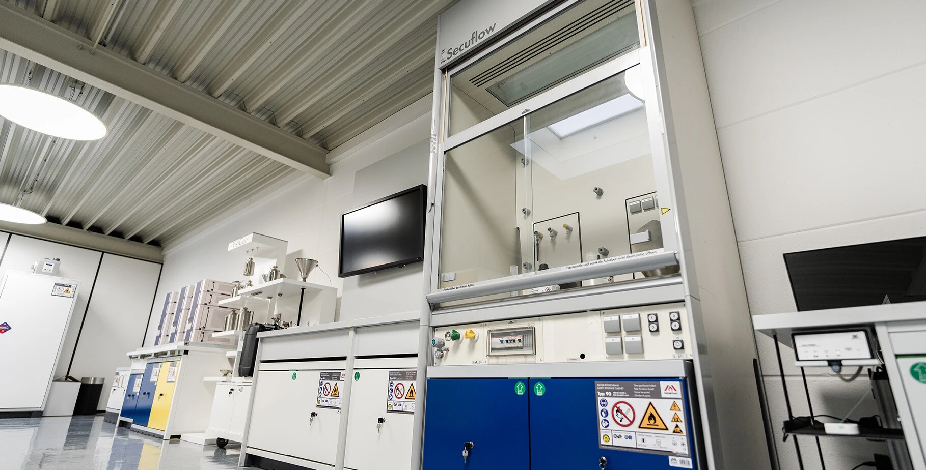 Laboratory mit einem Secuflow-Gerät, weißen Wänden und verschiedenen Arbeitsplatzmöglichkeiten.