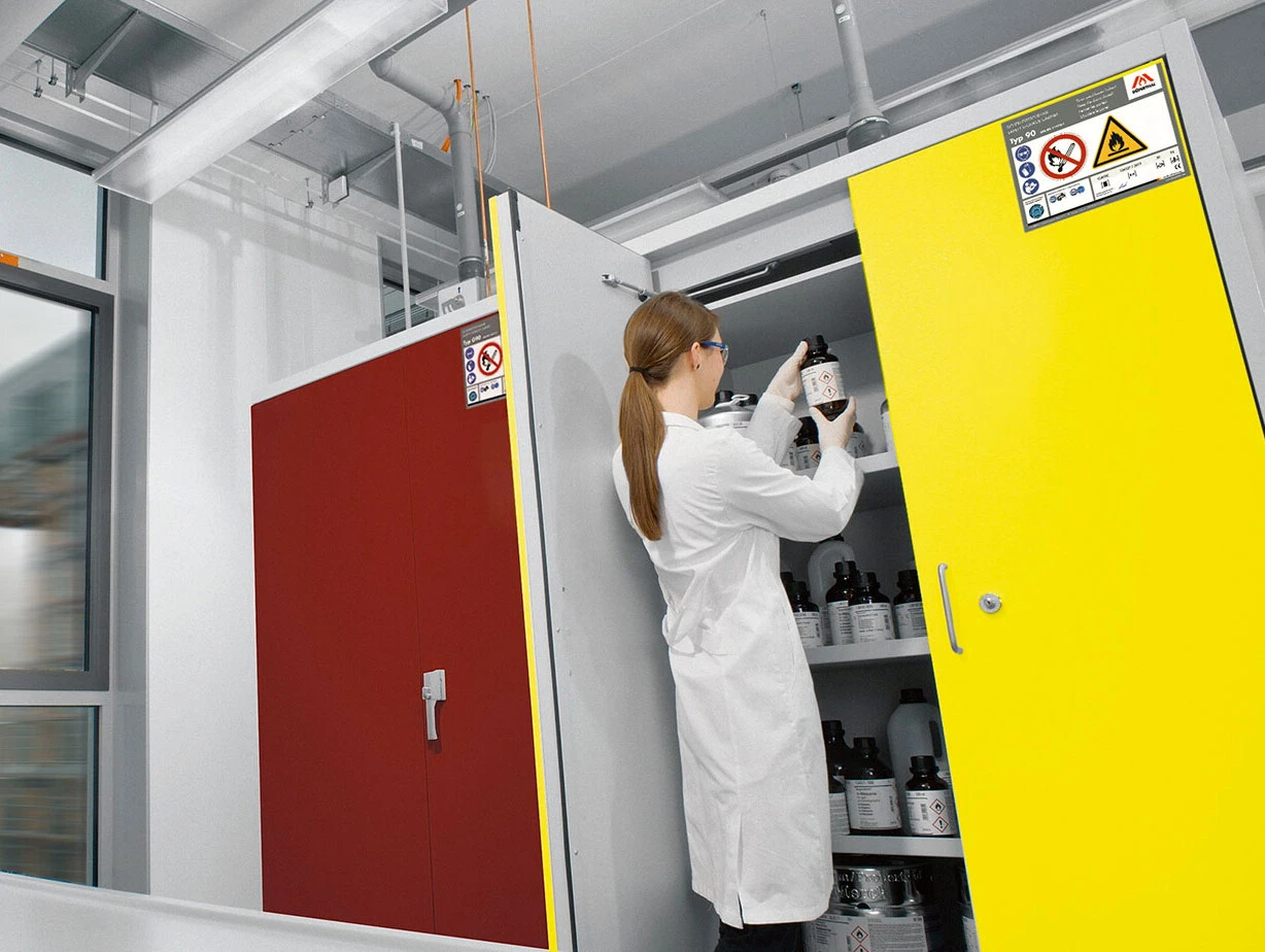 Laboratory mit zwei Wissenschaftlerinnen in weißen Laborkitteln, die mit Chemikalien arbeiten.