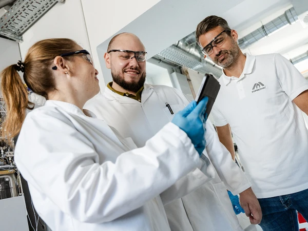 Three professional people locking on a Tablet
