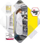 A person in a lab coat is organizing items on shelves in a laboratory setting, surrounded by award logos.