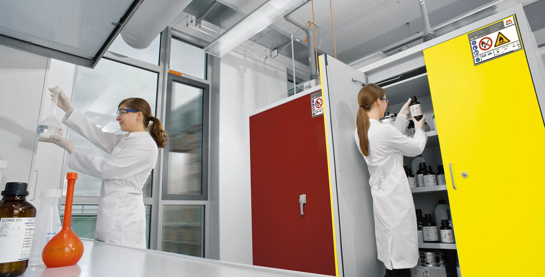Laboratoire avec deux femmes scientifiques en blouses blanches de laboratoire qui travaillent avec des produits chimiques.